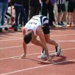 a person kneeling on a track